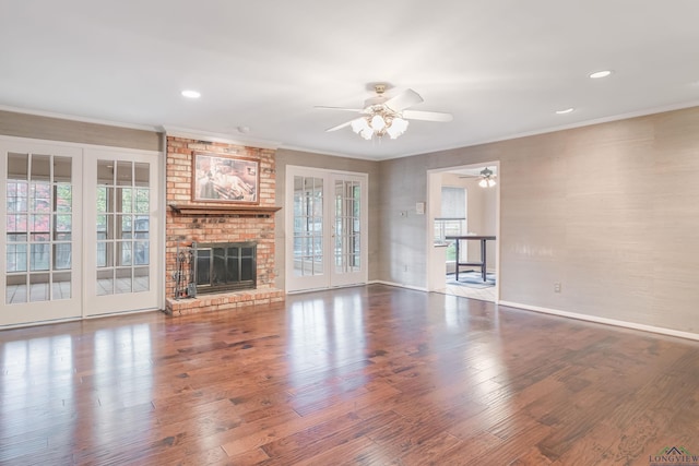 unfurnished living room with ceiling fan, a fireplace, hardwood / wood-style flooring, and ornamental molding