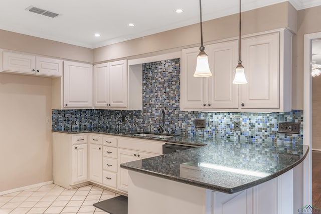 kitchen with sink, decorative light fixtures, dark stone countertops, white cabinetry, and light tile patterned flooring