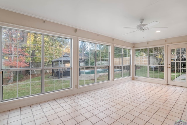 unfurnished sunroom with ceiling fan