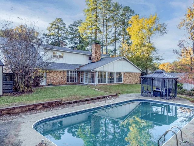 view of swimming pool with a gazebo and a yard