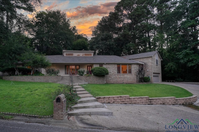 view of front of property with a garage and a lawn