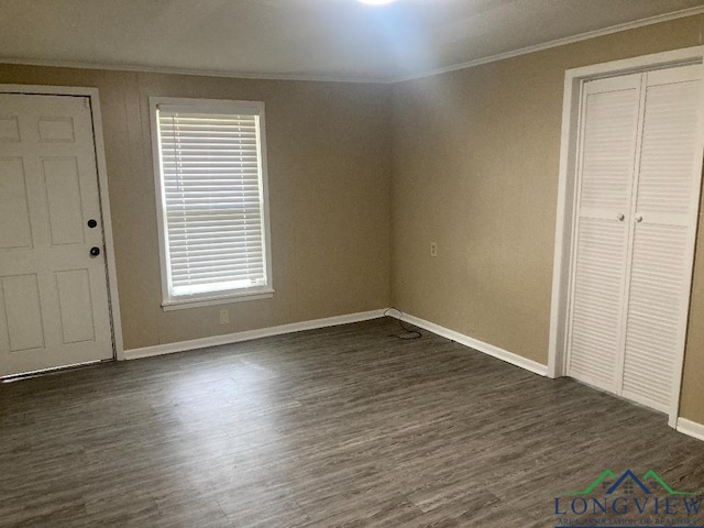 unfurnished bedroom featuring crown molding and dark hardwood / wood-style floors