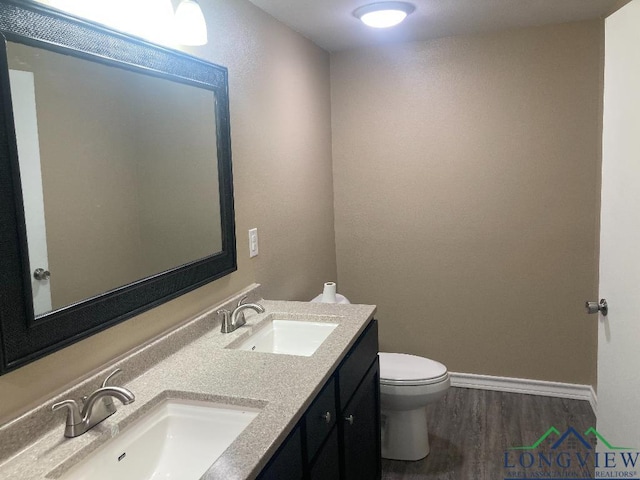 bathroom with toilet, vanity, and hardwood / wood-style flooring