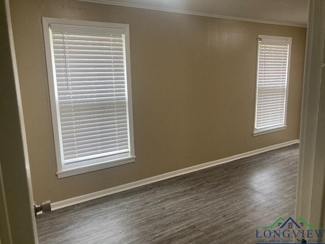 unfurnished room featuring ornamental molding and dark wood-type flooring