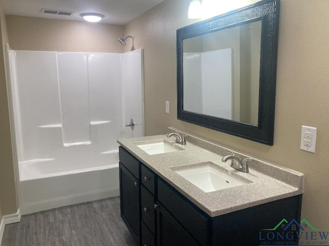 bathroom featuring vanity, shower / washtub combination, and hardwood / wood-style flooring