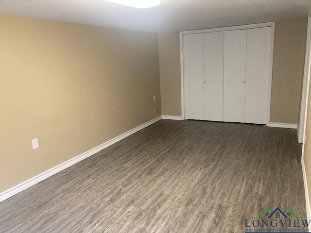 unfurnished bedroom with dark wood-type flooring and a closet