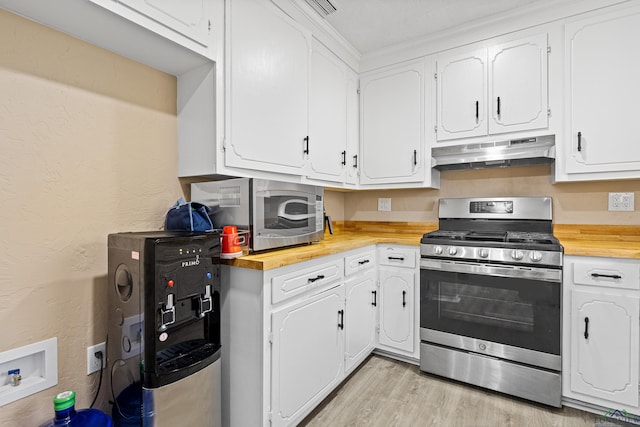 kitchen with stainless steel appliances, white cabinets, and light wood-type flooring