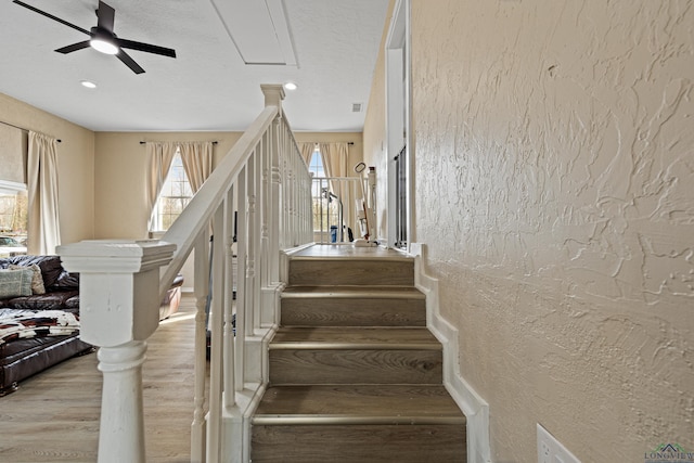 stairway featuring hardwood / wood-style flooring and ceiling fan