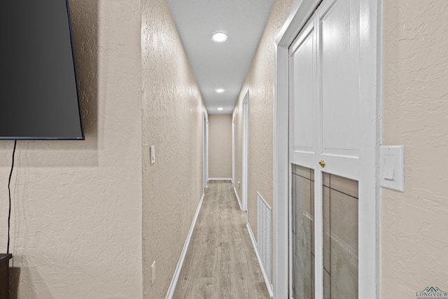 hallway with hardwood / wood-style flooring