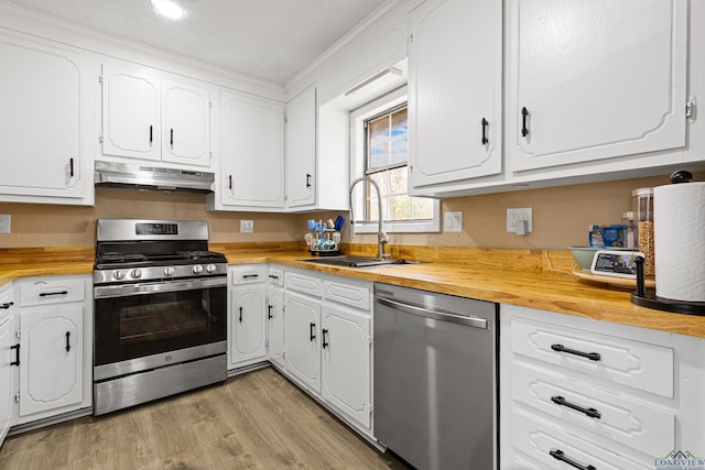 kitchen featuring white cabinetry, wood counters, appliances with stainless steel finishes, and sink