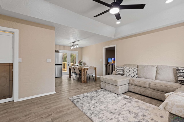 living room with hardwood / wood-style floors, a textured ceiling, and ceiling fan