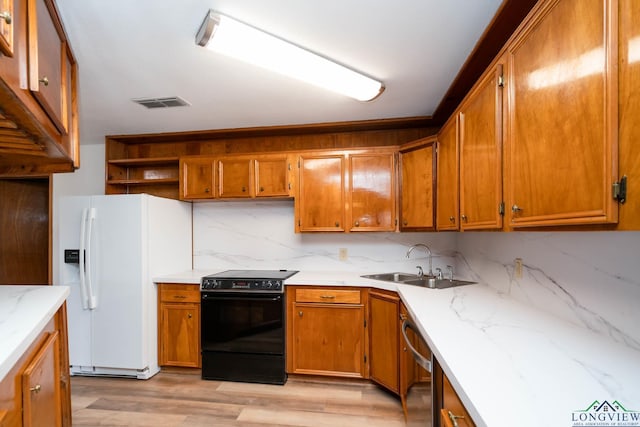 kitchen with black / electric stove, a sink, visible vents, dishwasher, and white fridge with ice dispenser