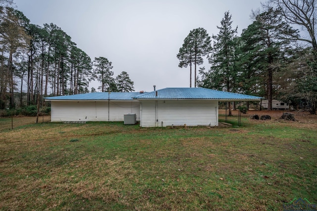 rear view of property featuring metal roof and a yard