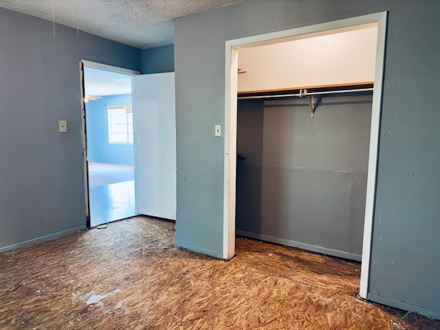 unfurnished bedroom featuring a textured ceiling and a closet