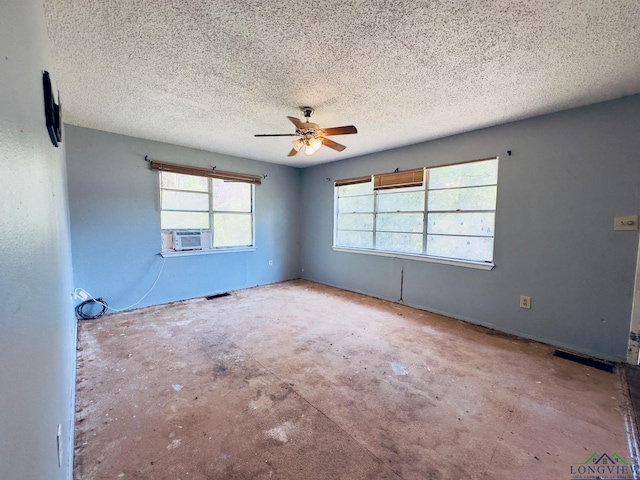 empty room featuring ceiling fan, cooling unit, and a textured ceiling