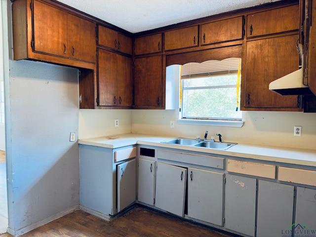 kitchen featuring a textured ceiling, sink, extractor fan, and dark hardwood / wood-style floors