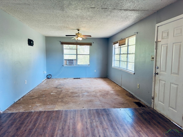 interior space with ceiling fan, cooling unit, and a textured ceiling