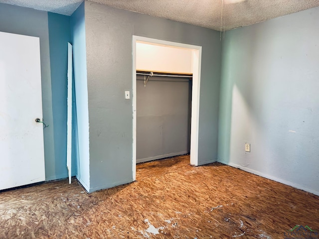 unfurnished bedroom with a textured ceiling and a closet