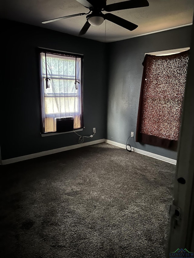 carpeted empty room featuring baseboards and a ceiling fan