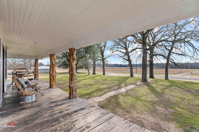 deck with a yard and a rural view