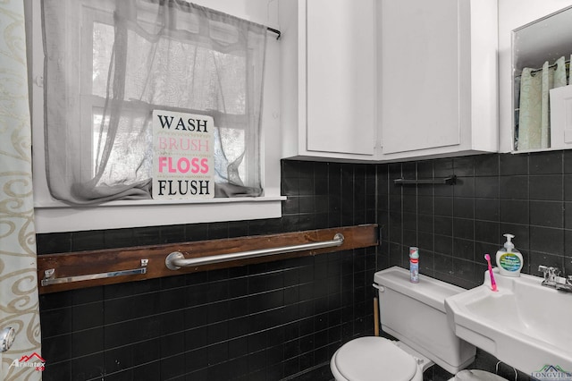 bathroom featuring sink, tile walls, backsplash, and toilet