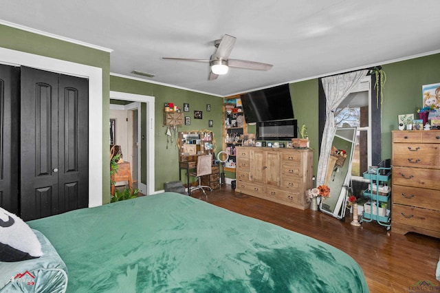 bedroom featuring crown molding, ceiling fan, dark hardwood / wood-style flooring, and a closet