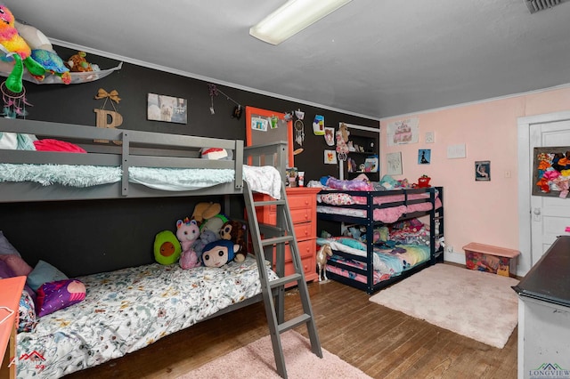 bedroom with wood-type flooring and ornamental molding