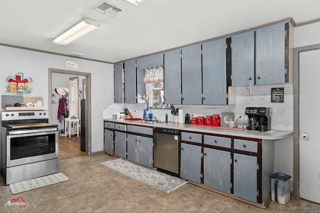 kitchen with gray cabinetry, crown molding, tasteful backsplash, and stainless steel appliances