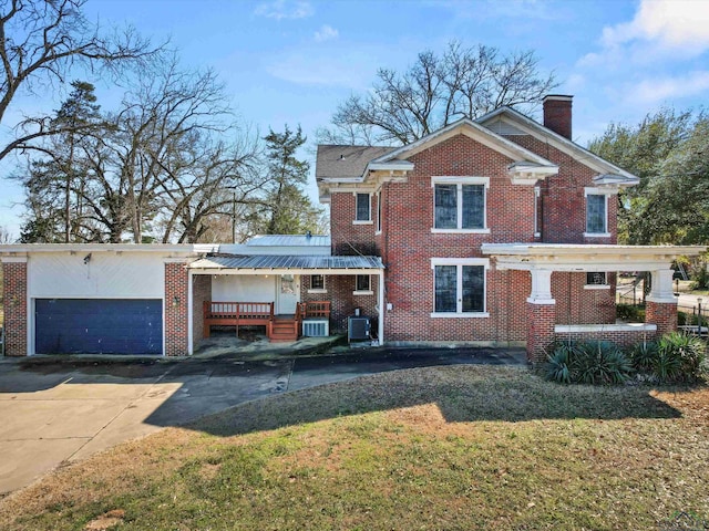 view of front of property featuring driveway, brick siding, a chimney, and cooling unit