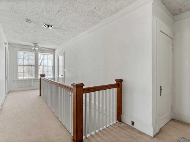 corridor with carpet, an upstairs landing, and visible vents