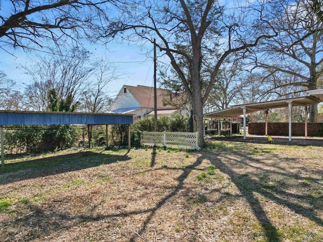 view of yard with a carport and fence