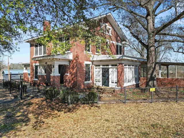 exterior space with a fenced front yard, brick siding, and a chimney