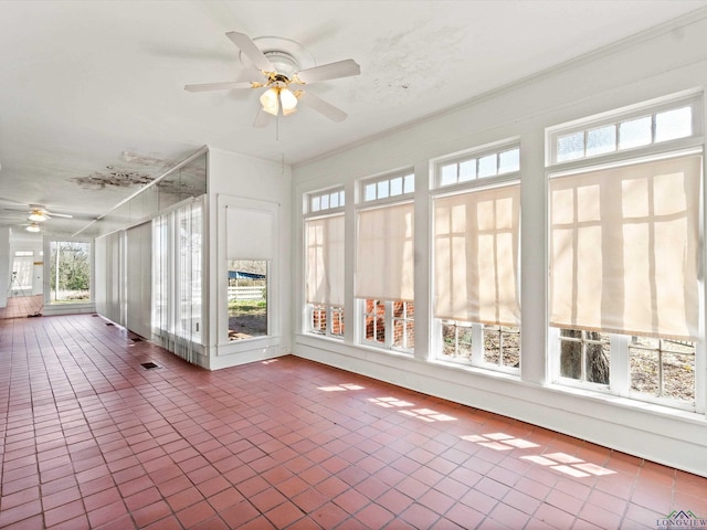 unfurnished sunroom featuring ceiling fan