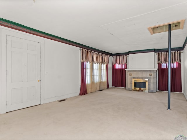 unfurnished living room featuring a glass covered fireplace, carpet flooring, and visible vents