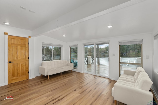 living room with vaulted ceiling with beams and light wood-type flooring