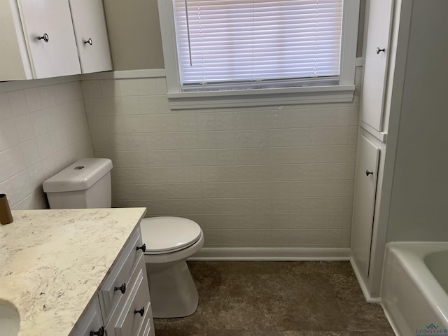 bathroom featuring a healthy amount of sunlight, vanity, toilet, and a bathtub