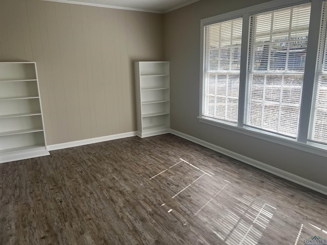 empty room with crown molding, wood-type flooring, and a wealth of natural light