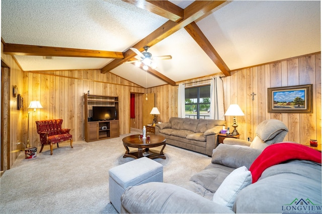 living room featuring a textured ceiling, lofted ceiling with beams, ceiling fan, and carpet floors