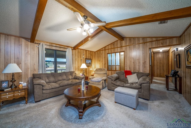 carpeted living room with a textured ceiling, lofted ceiling with beams, and ceiling fan