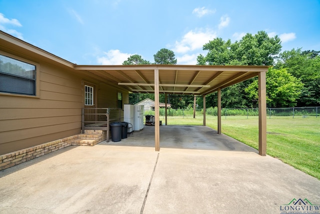 view of parking / parking lot with a carport and a lawn