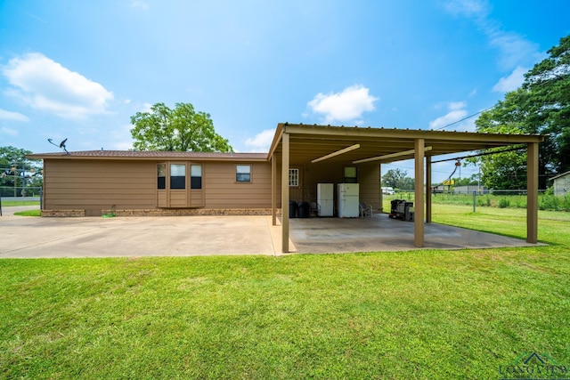 rear view of house featuring a lawn and a carport