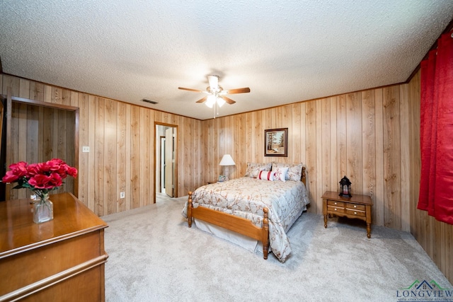 carpeted bedroom with ceiling fan and a textured ceiling