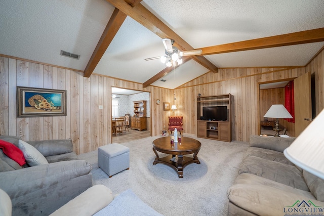 living room featuring ceiling fan, a textured ceiling, lofted ceiling with beams, and carpet flooring