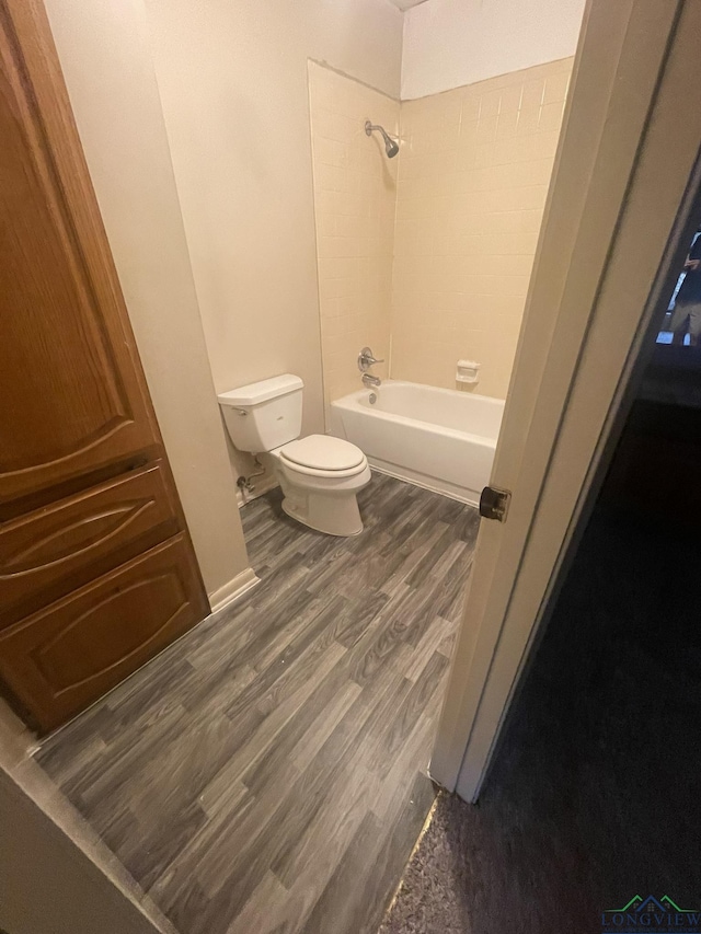 629 Baylor Dr, Longview, TX 75601 - bathroom featuring toilet, wood finished floors, and washtub / shower combination