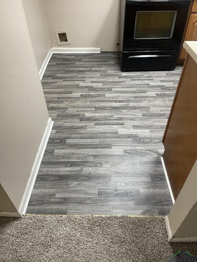 629 Baylor Dr, Longview, TX 75601 - detailed view of stove, wood finished floors, and baseboards