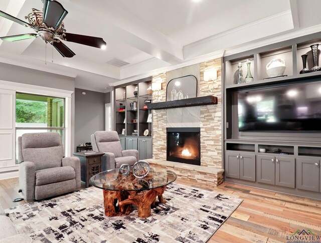 living area with visible vents, hardwood / wood-style floors, a fireplace, a ceiling fan, and built in shelves