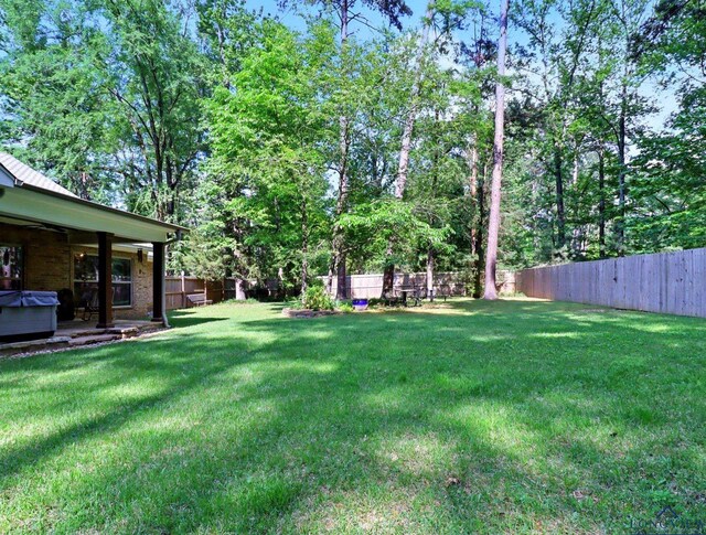 view of yard featuring a fenced backyard and a hot tub