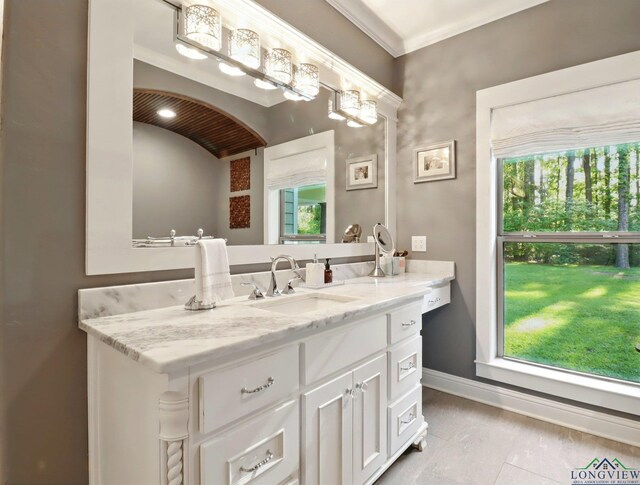 bathroom with a wealth of natural light, vanity, and baseboards