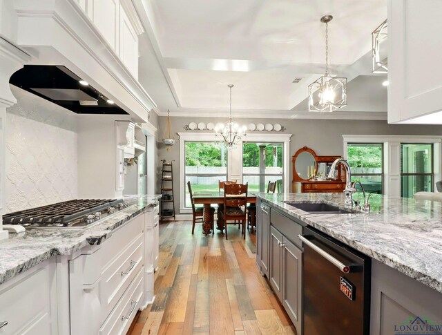 kitchen with light wood-style flooring, a sink, a chandelier, plenty of natural light, and dishwasher
