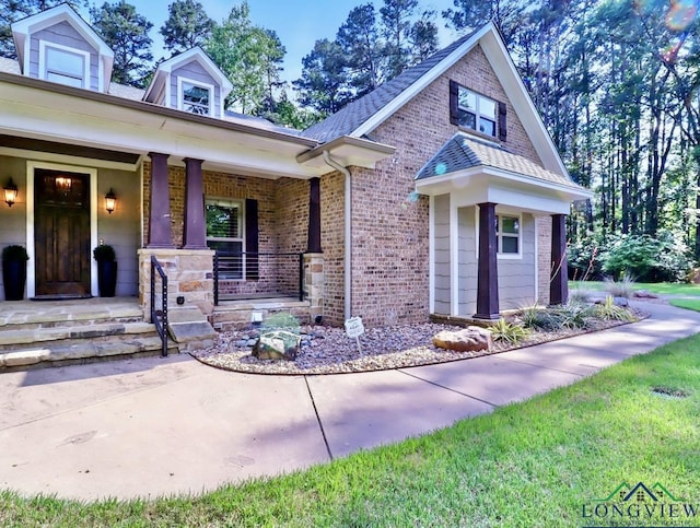 view of front of home with covered porch and brick siding